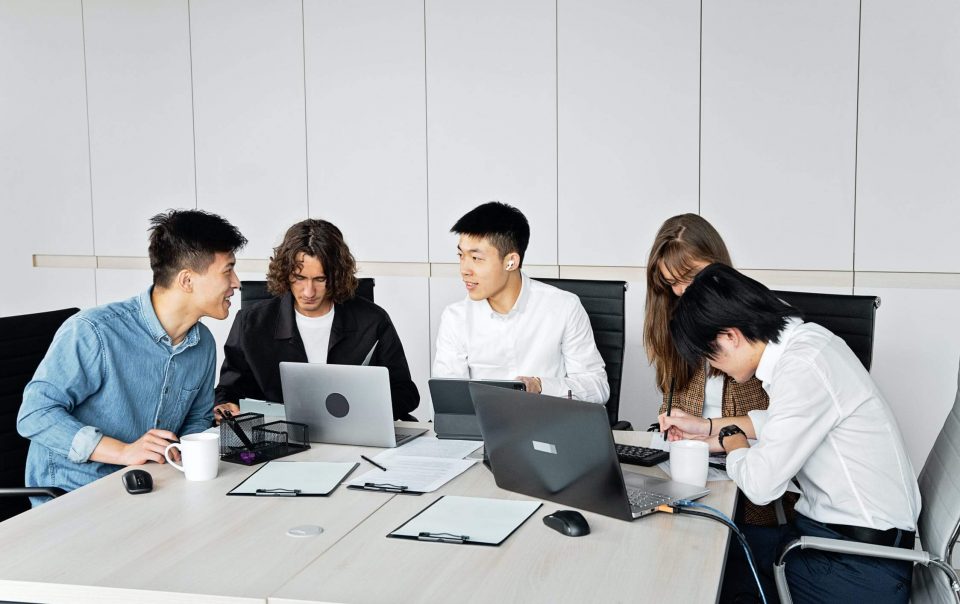 A Group of Office Workers Huddled In a Room