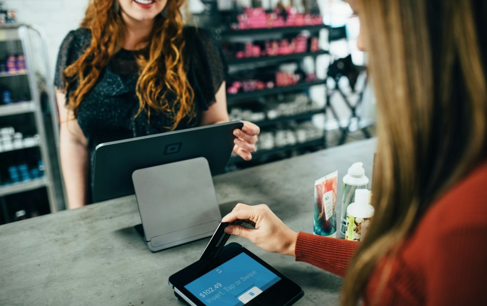 A Woman Swiping a Card on a POS System