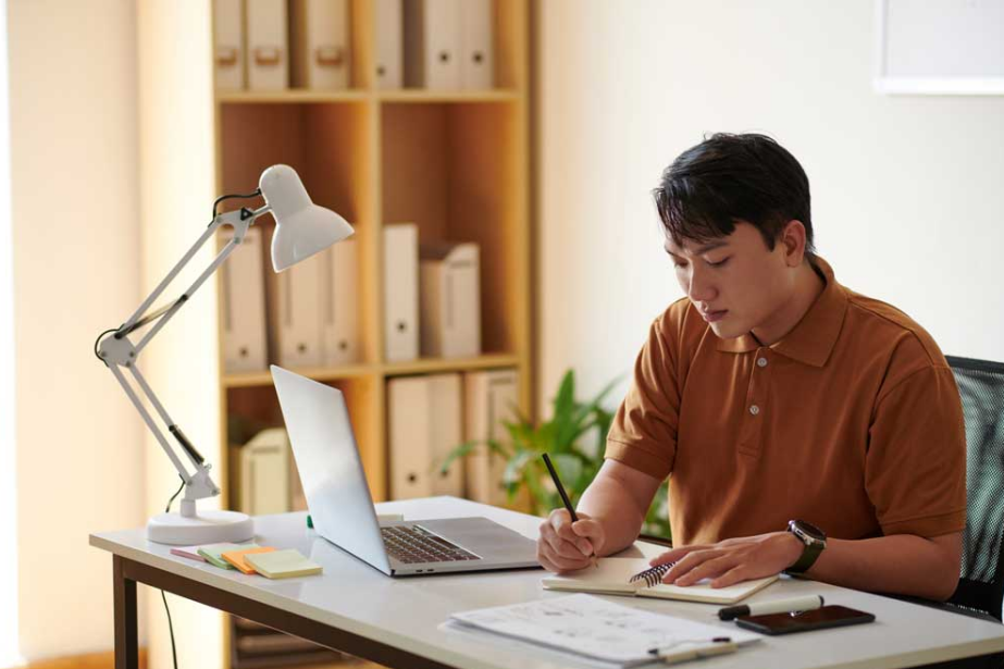 A Man Writing in a Notebook