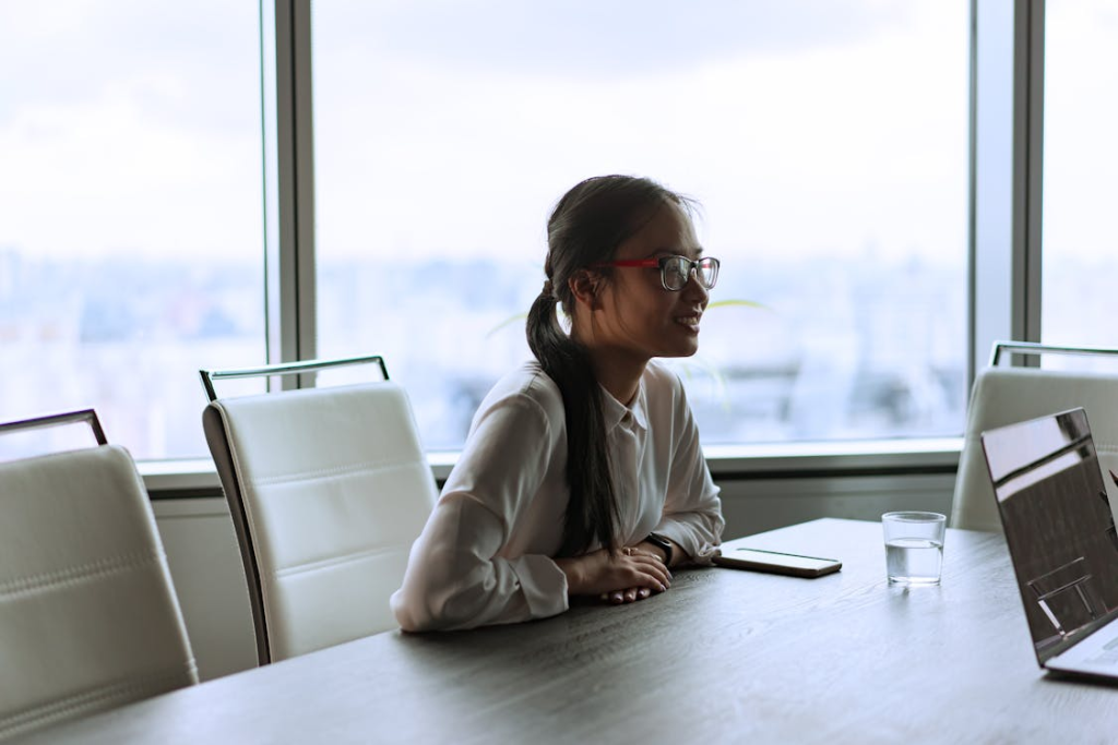 A Smiling Female Corporate Employee Sitting Inside an Office