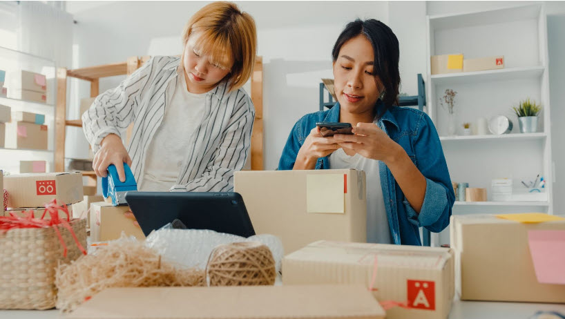 Two Female Entrepreneurs Packing Inventory Items